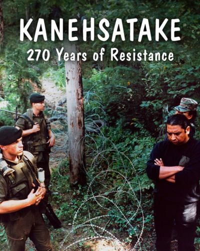 Cover image for film with text: "Kanehsatake: 270 Years of Resistance". Image shows Mohawk land defenders standing on right, across a roll of barbed wire from Canadian Armed Forces soldiers. 