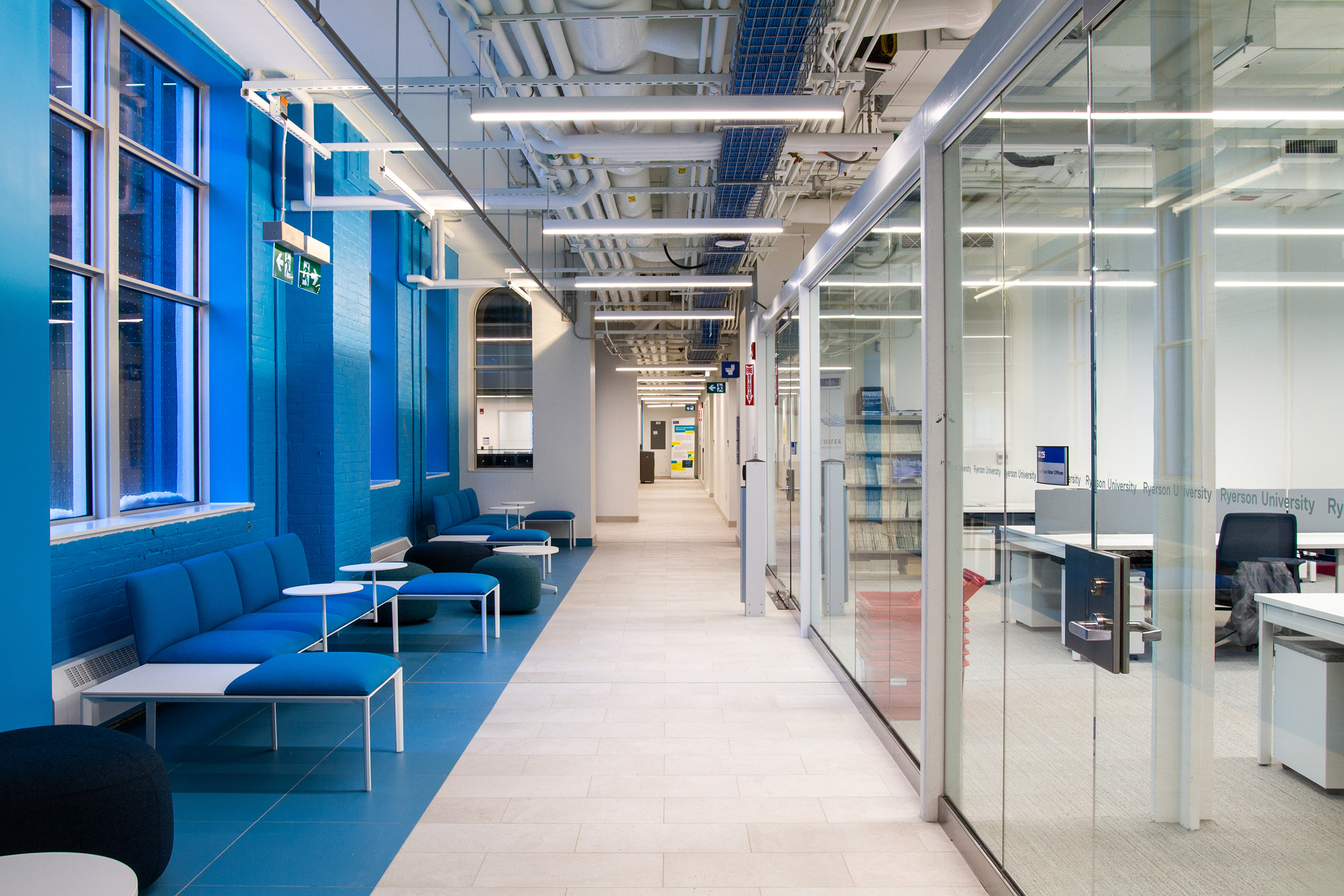 A side hallway in the Centre for Urban Innovation, showcasing seating area and blue brick wall