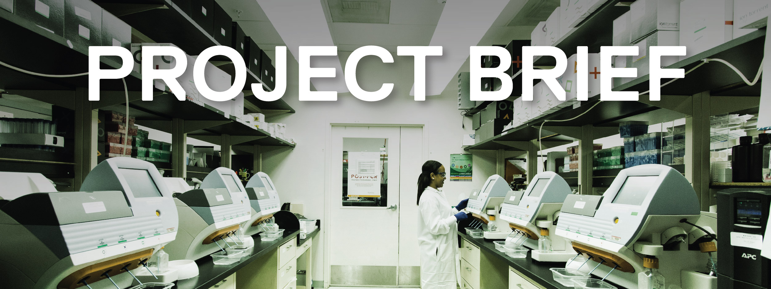 A technician works in a lab in front of a desktop genomic sequencing machines