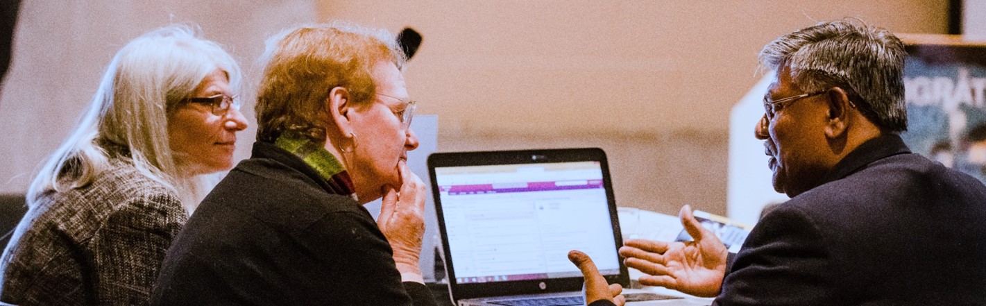 Image of three scholars, one scholar using hand gestures while talking