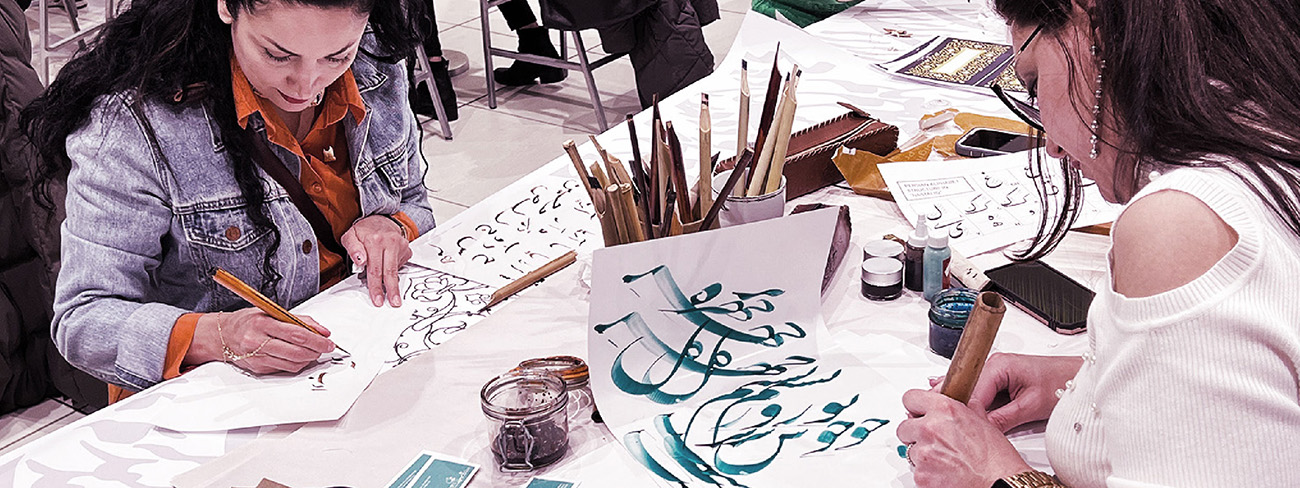 Two women writing in a Farsi calligraphy workshop