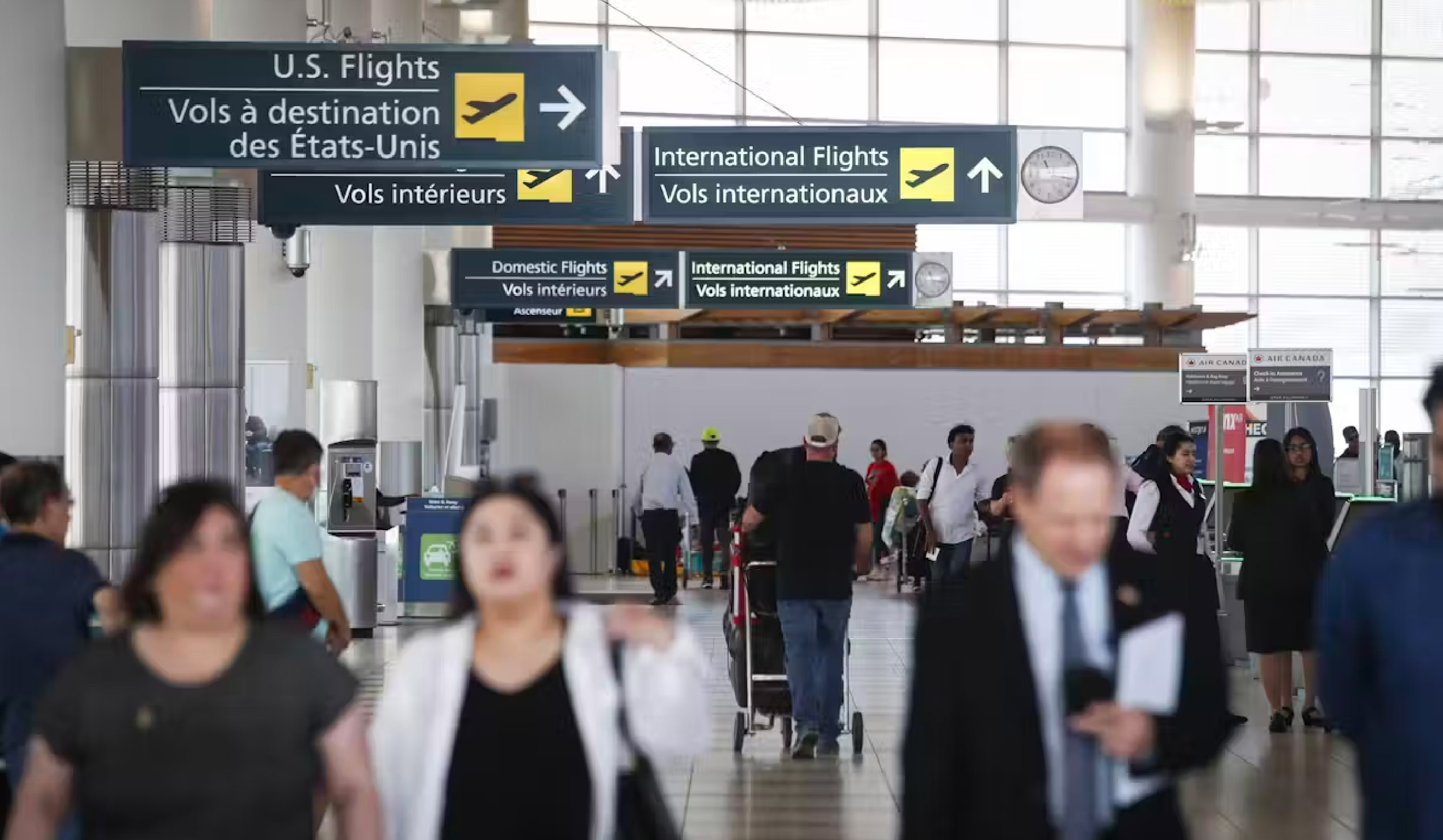 Passengers and signage at Winnipeg airport in June 2023