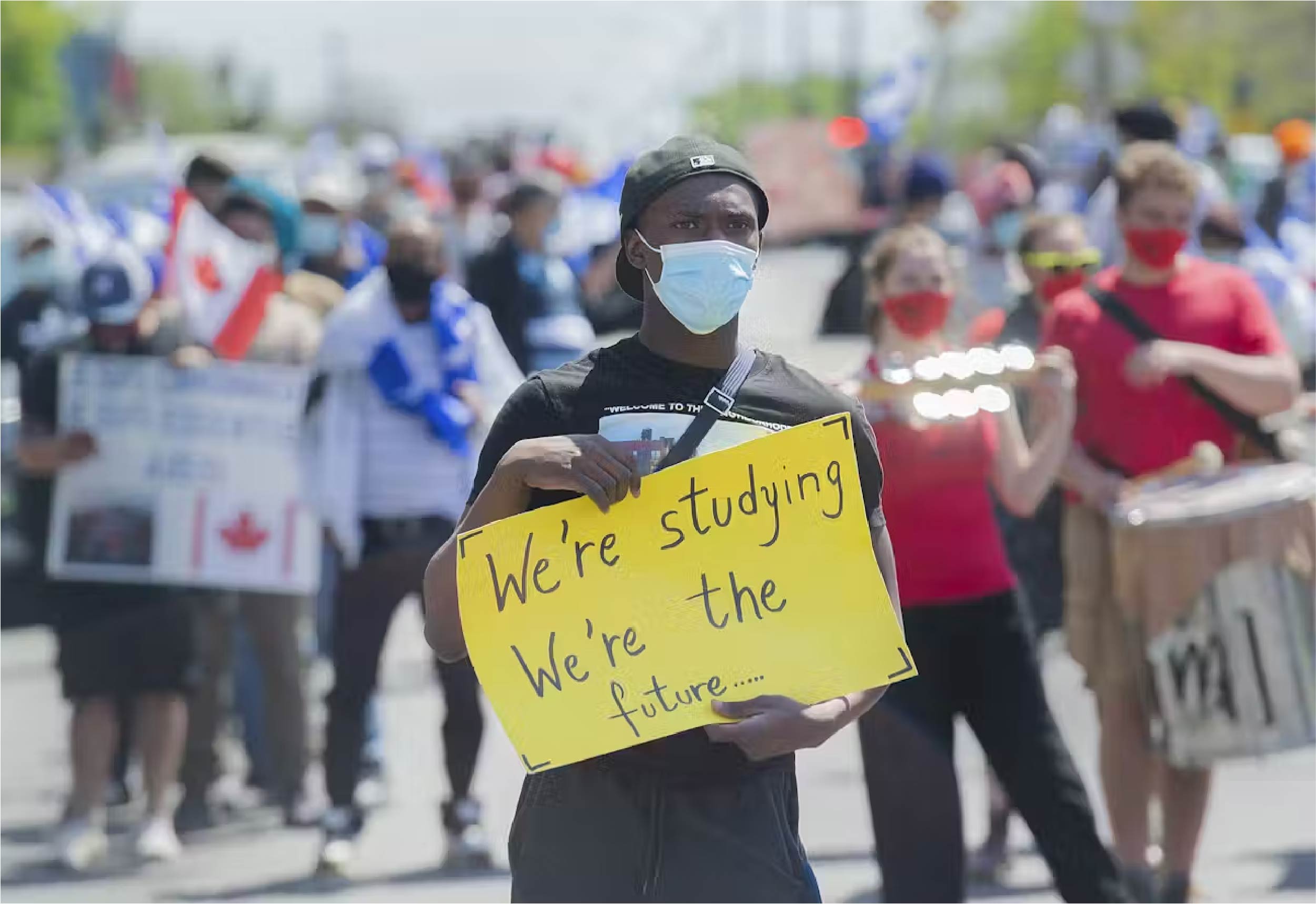 People take part in a rally in May 2021 calling on the federal government to expand the permanent status program to include all refugees, international students, undocumented migrants and temporary foreign workers near Prime Minister Justin Trudeau’s constituency office in Montréal