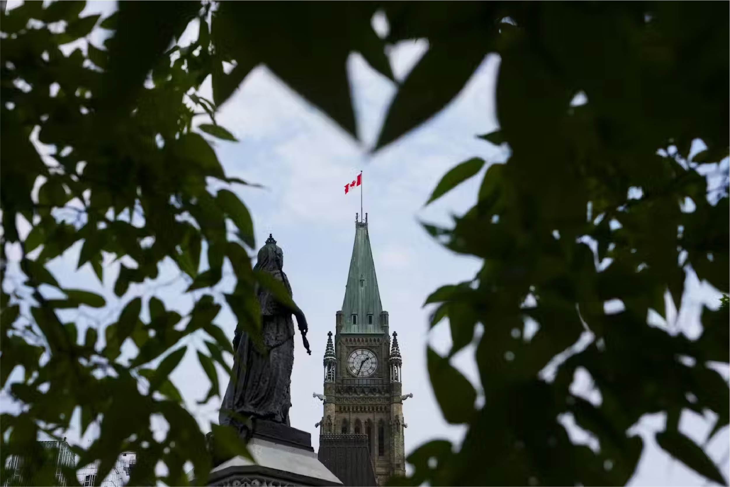 The Peace Tower on Parliament Hill is framed by leaves in Ottawa in August 2024