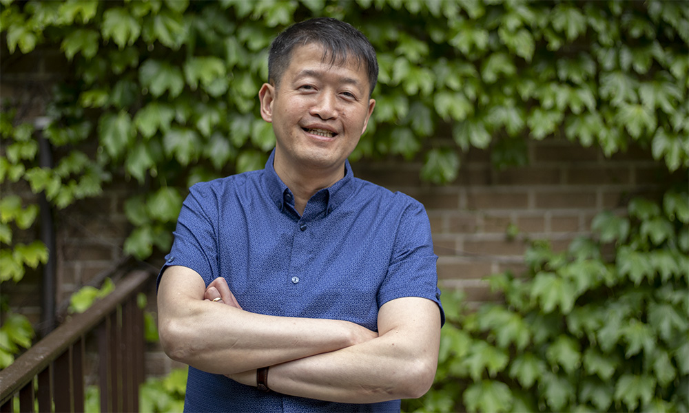 Dr. Philip K. Chan stands outside with folded arms