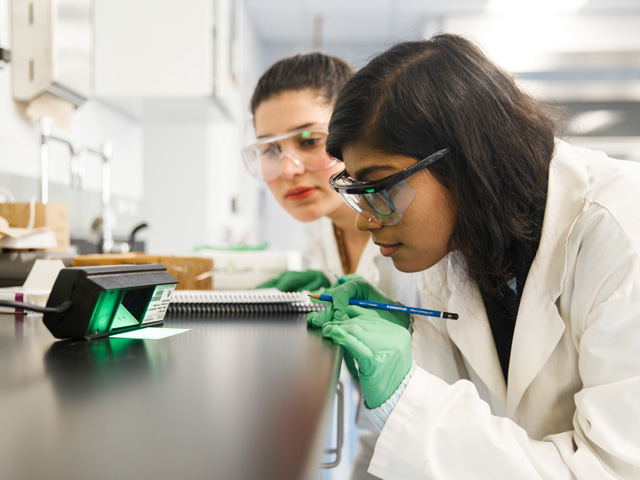 Chemistry and Biology students working on gene research in lab.