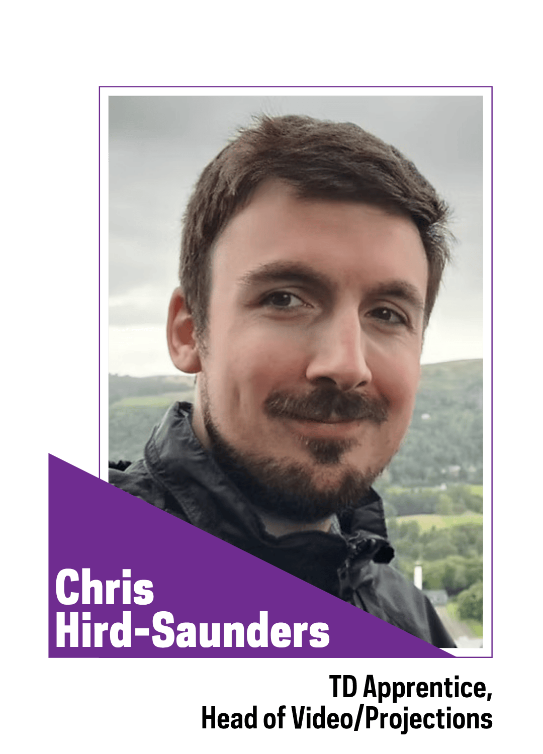 smiling man with facial hair standing outside 