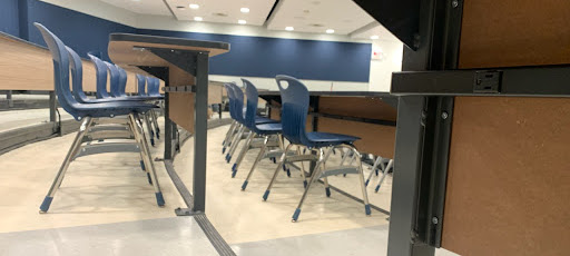 A desk in a tiered classroom with an under-desk power bar
