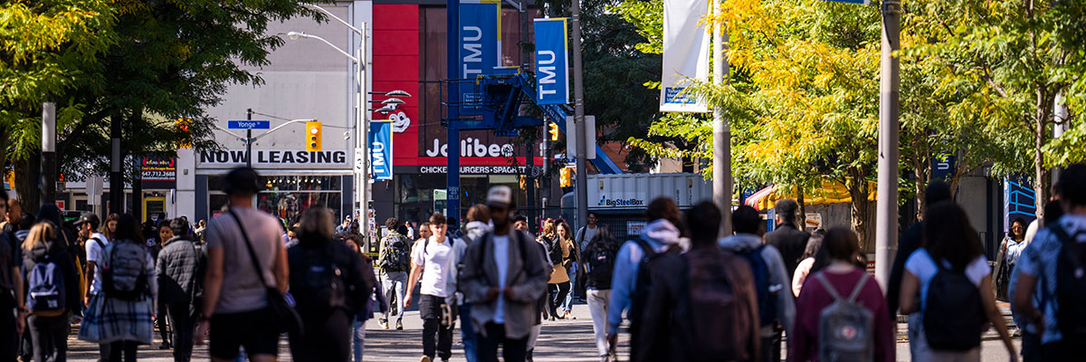 Looking westward on Gould Street to Yonge Street with TMU flags on the poles.