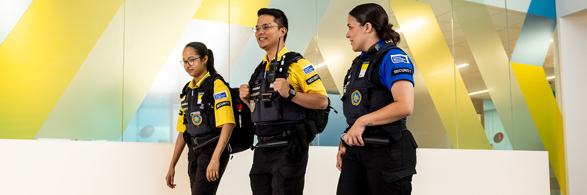 Three TMU Security team members walking past the Service Hub.
