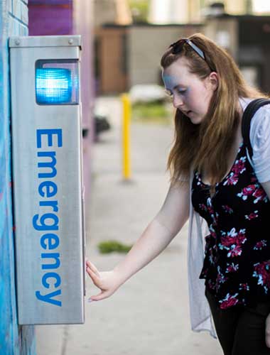 Person making a call at an emergency station on campus.