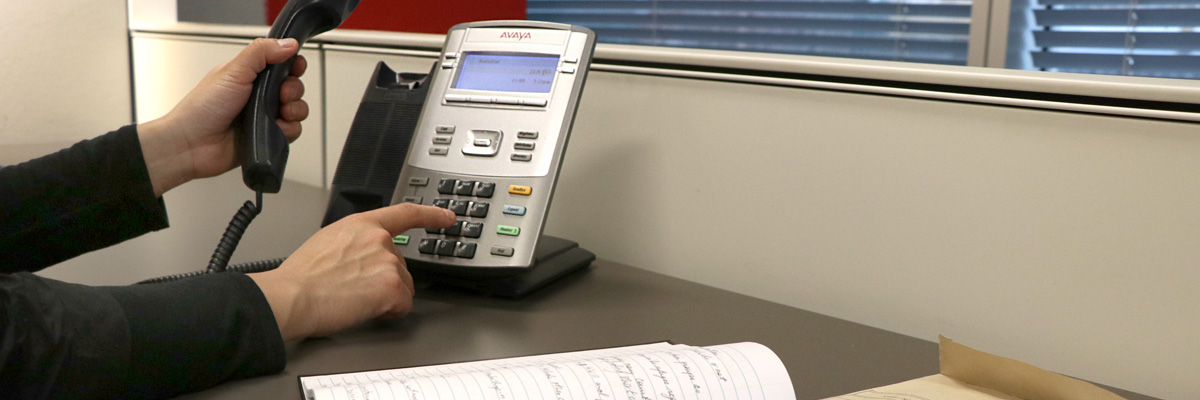 Person dialling a number on an internal phone.