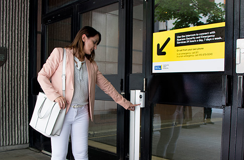 Community member pressing the intercom button outside of the Victoria Building.