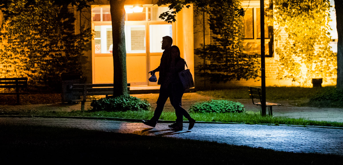 Silhouette of two people walking at night.