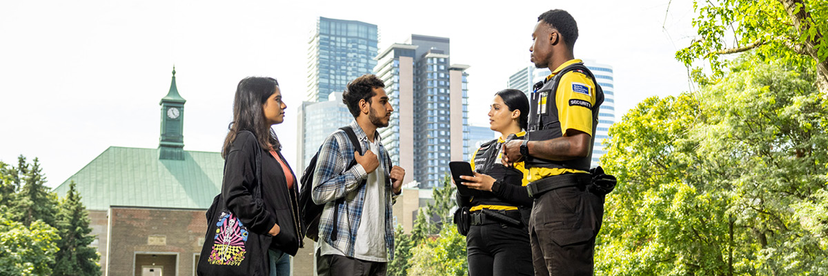 Person speaking with two members of the security team who take notes.