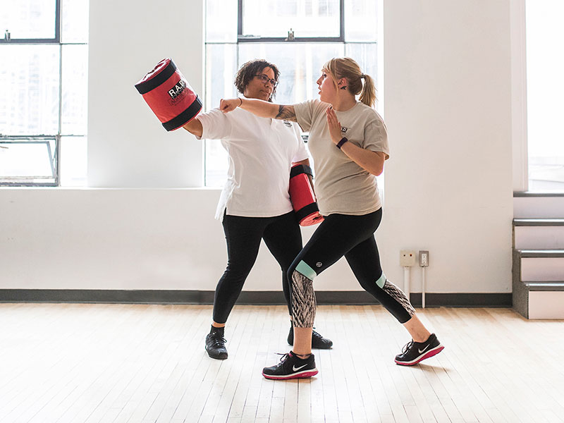 Two women practicing self defence moves.