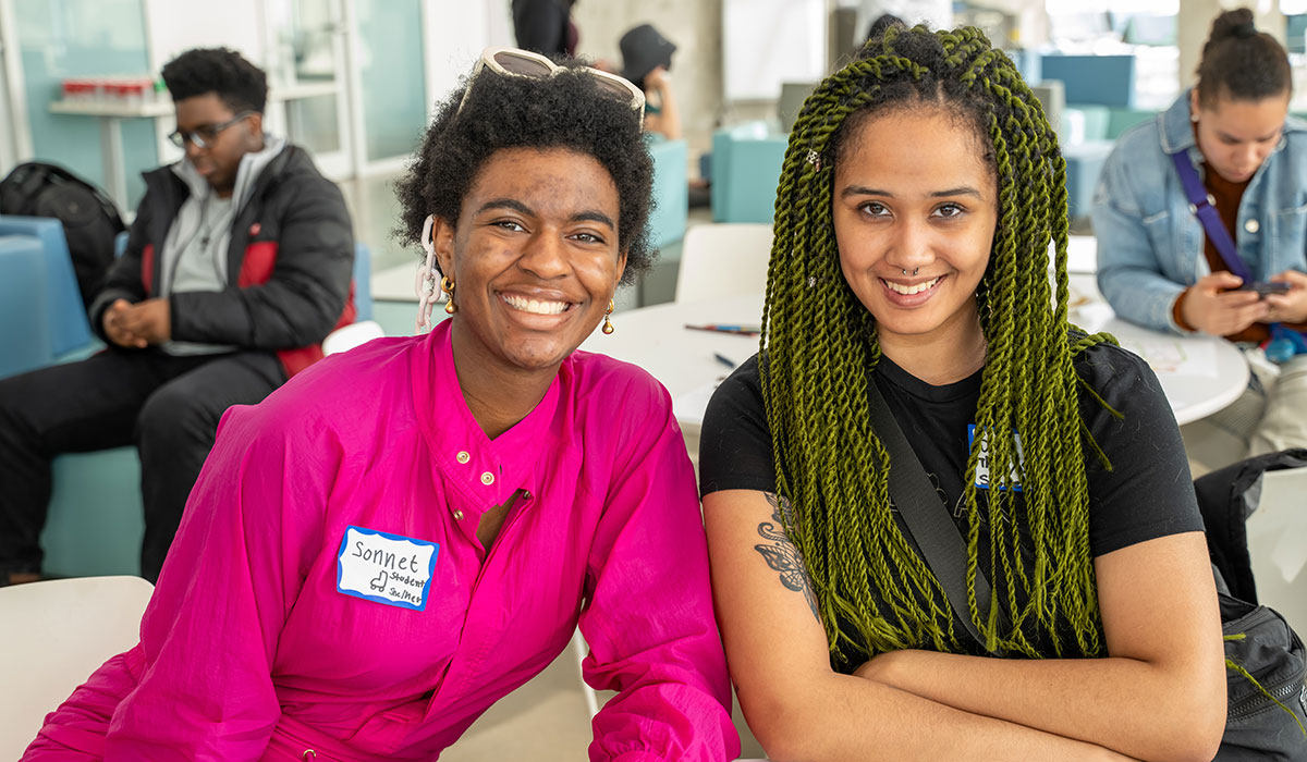 Black students, Sonnet Hines and Sara Eyre, smiling at the Black Excellence Mixer.