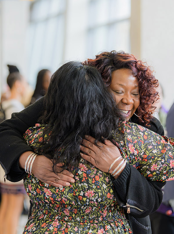 Black staff, Nikki Waheed, hugging another attendee at the Alan Shepard Equity, Diversity and Inclusion Awards.