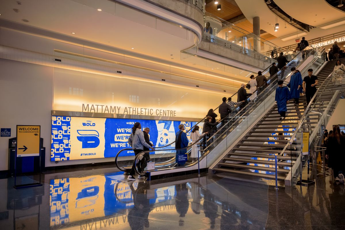 Graduands and guests using the stairs and escalators in the lobby of the Mattamy Athletic Centre 