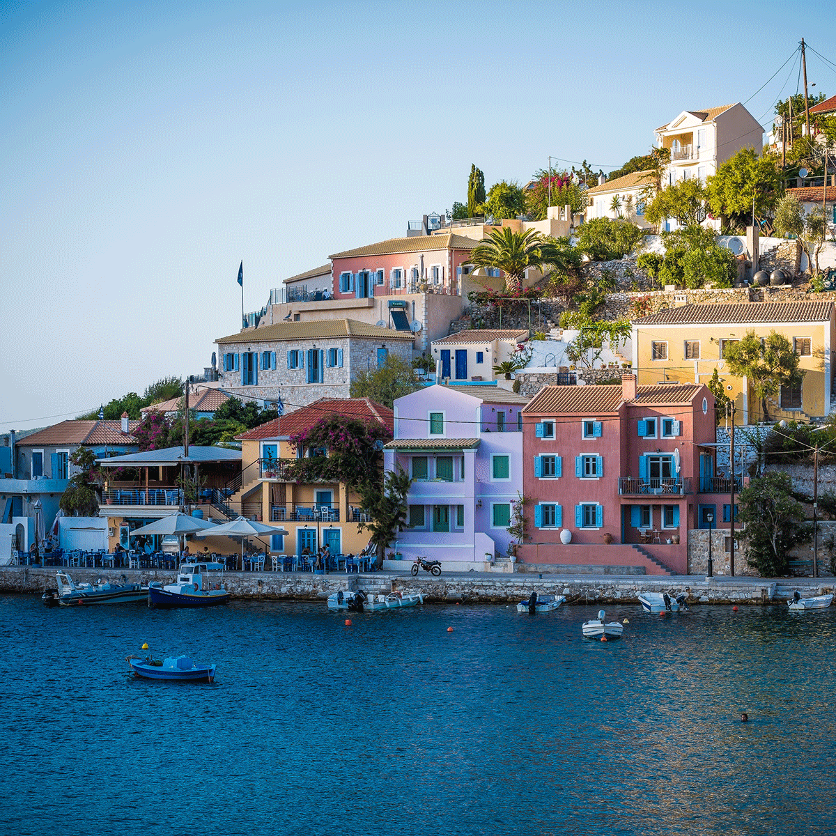 Colourful homes on the side of hill ocean side in Greece.