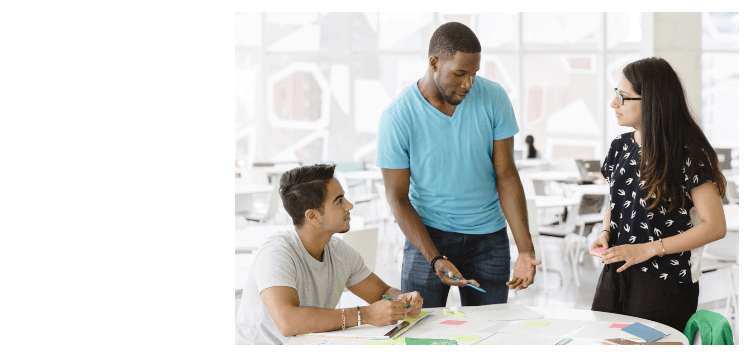 3 students working together at a table in the SLC building