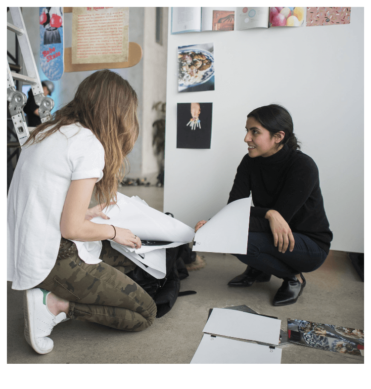 Two students arranging artwork in a gallery