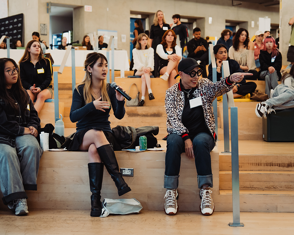 Students attend an event called Industry Night where they learn from creative executives. Here, a student asks a question to a panel of Creative Industries alumni.