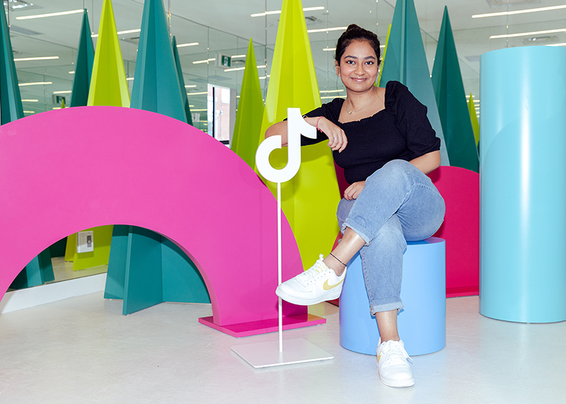 A Creative Industries student posing at the TikTok Canada office, the site of their internship.