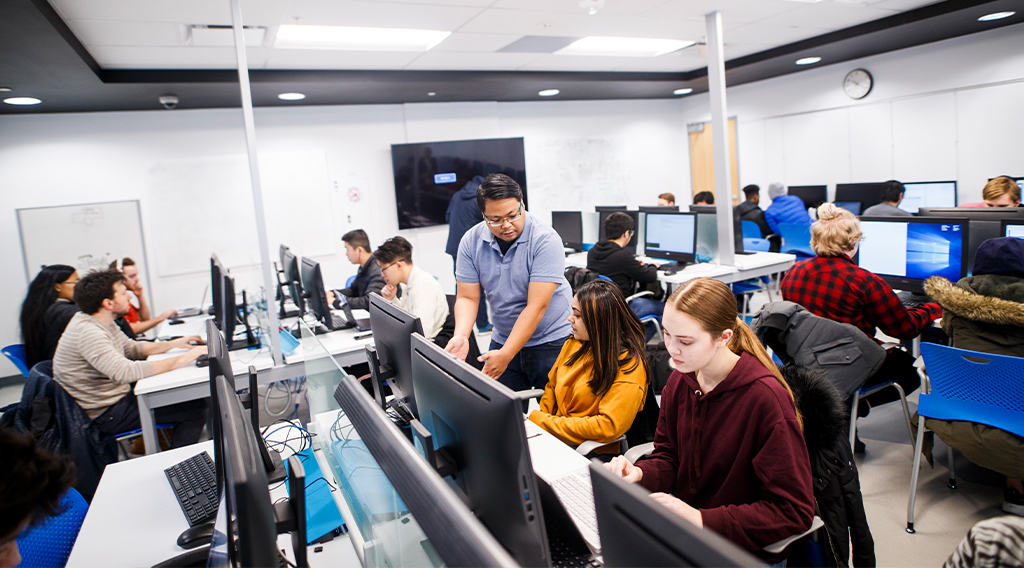 Instructor helping students in computer lab