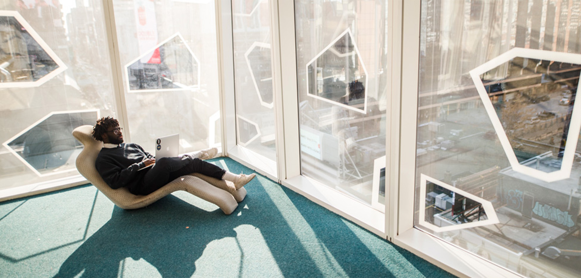 Student laying on a chair with their laptop in the SLC