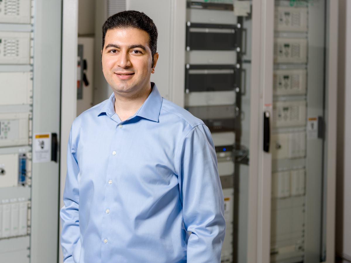 A male with a blue shirt is standing in the Schneider Electric Smart Grid Laboratory.
