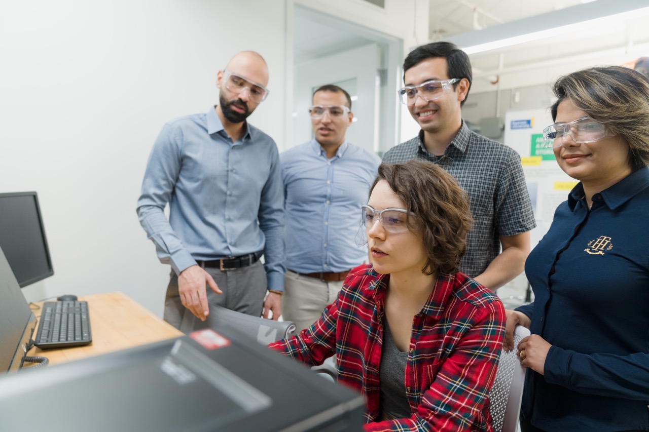 Researchers around a computer, looking at data