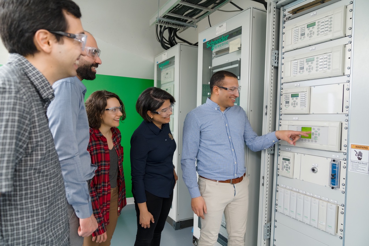 Researchers in the lab, looking at machinery