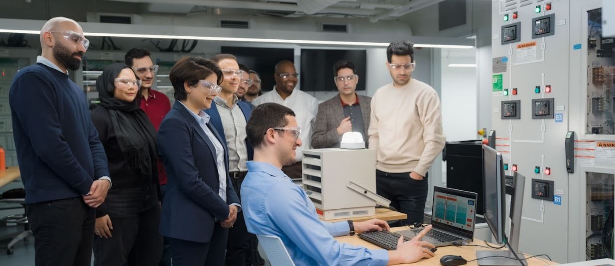 Group of Students in Smart Grid Lab looking at Project on Laptop together
