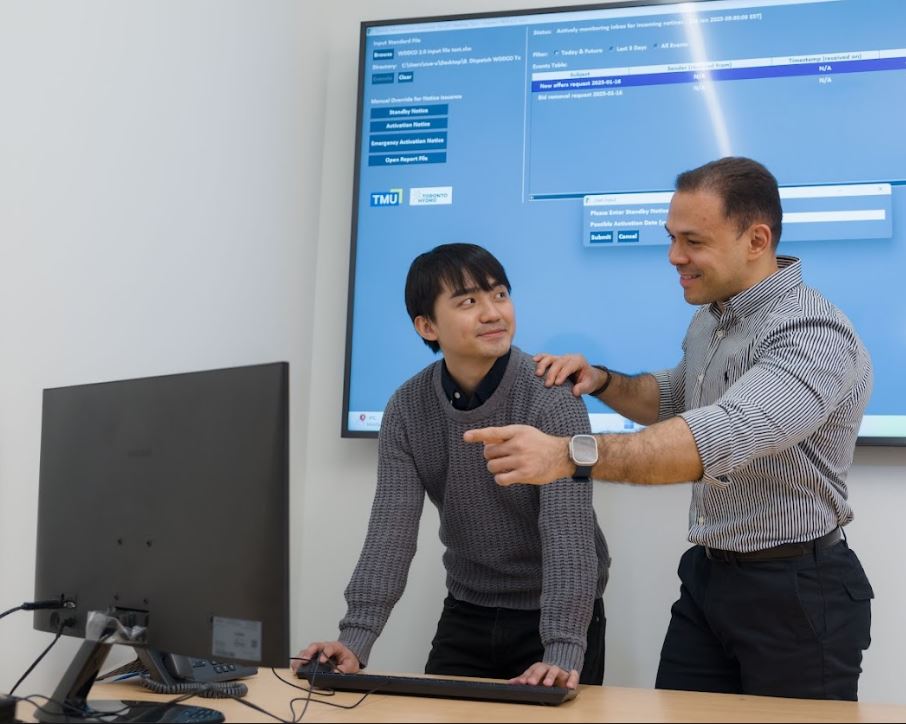 2 researchers on computer, 1 using the mouse and keyboard, 1 pointing and talking to the other researcher