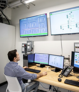 Researcher Thiago Fernandes working in the Schneider Electric Smart Grid Lab Control Room