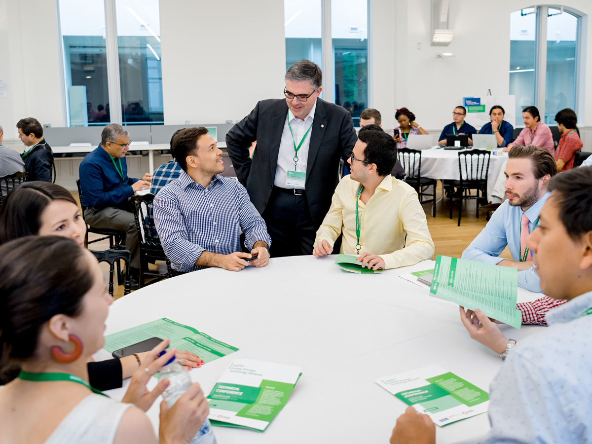 Attendees sitting at tables and discussing at 2019 NEST week