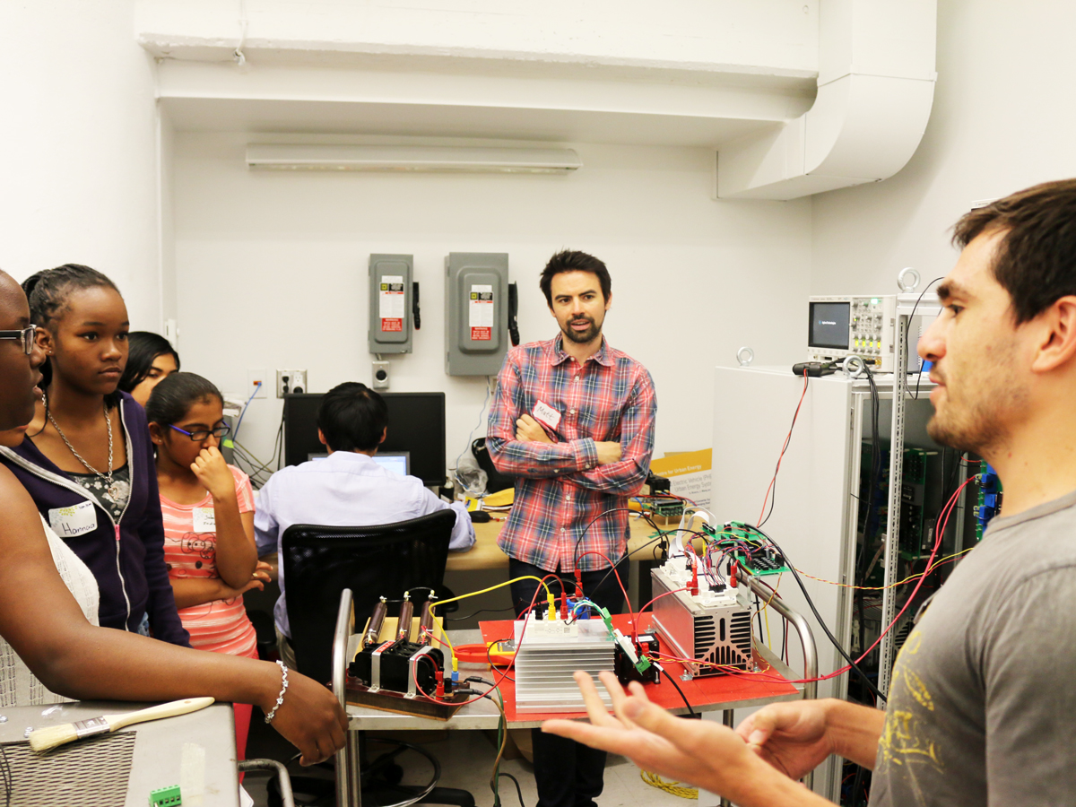 Sebastian Rivera presents research to STEM girls. 