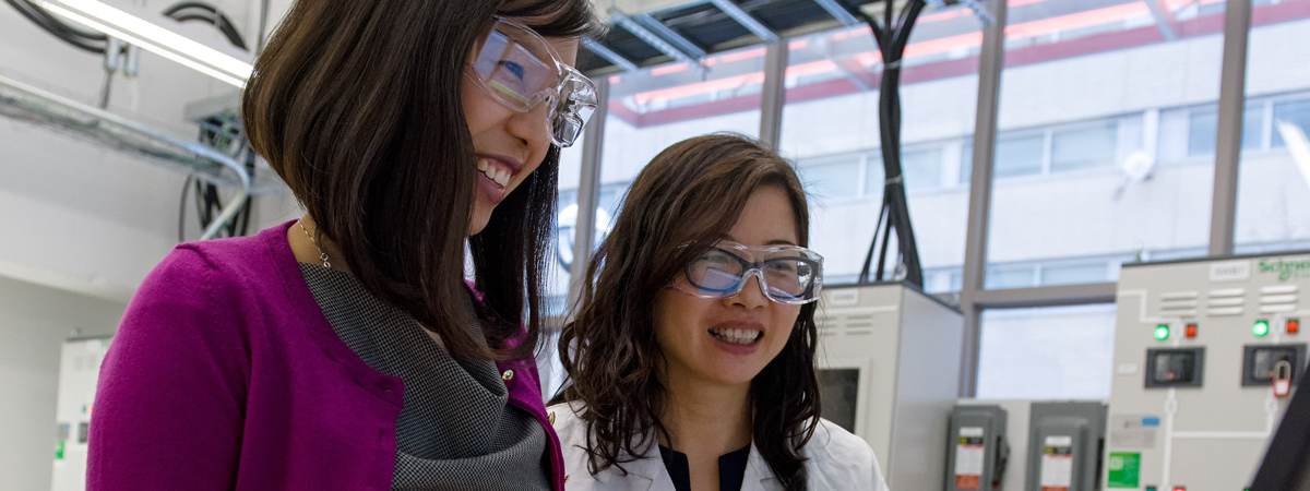 Researchers talking in a lab while wearing protective eyewear 