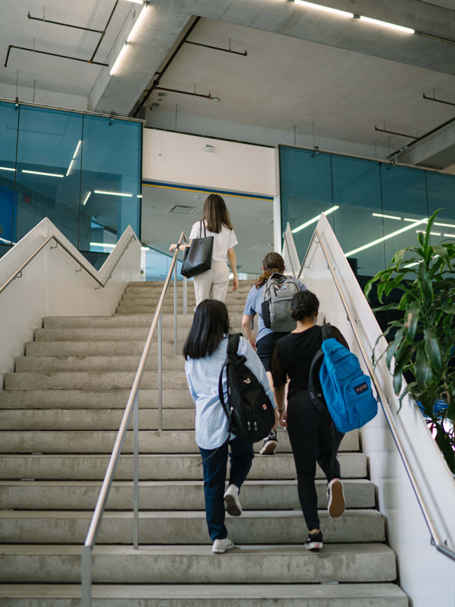 A group of students walk up the stairs at the SLC.