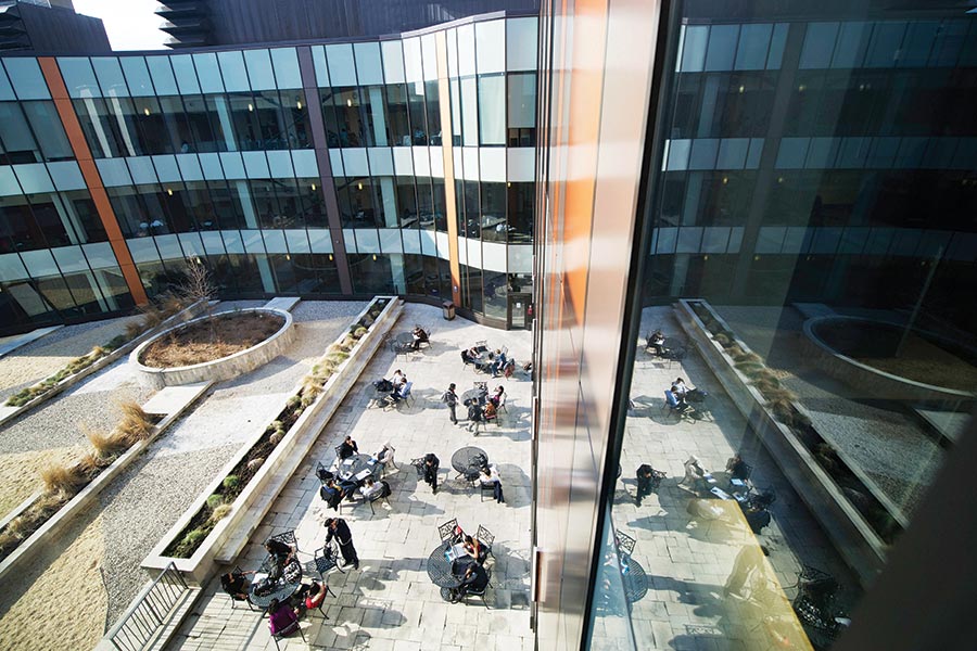An aerial view of the Ted Rogers School of Management courtyard. People are seen sitting at patio tables.