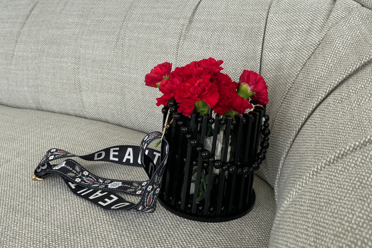 A black cylindrical bag made from laser cut parts resting on a couch.