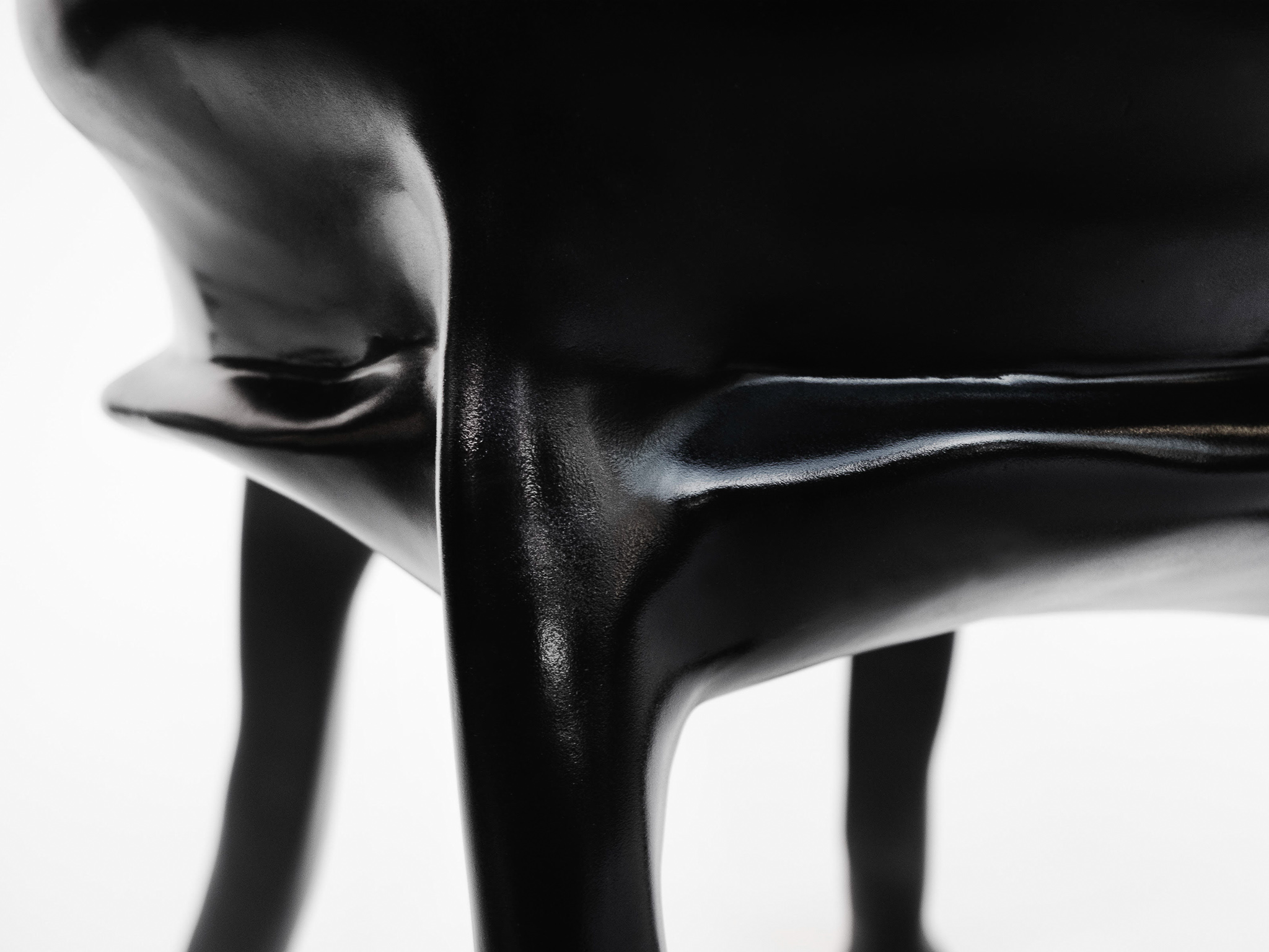 close-up photo of the surface texture of the chair. Black, glossy and the slightest bit grainy.