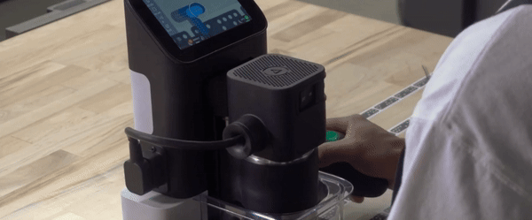 A technician operating a Shaper handhelp CNC router