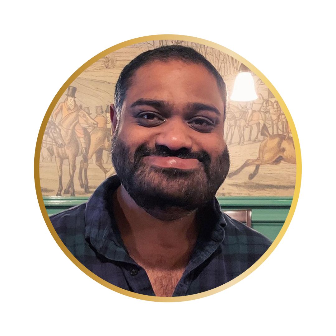 A photo of a south Asian man with short dark hair and a beard with a visible facial disability.