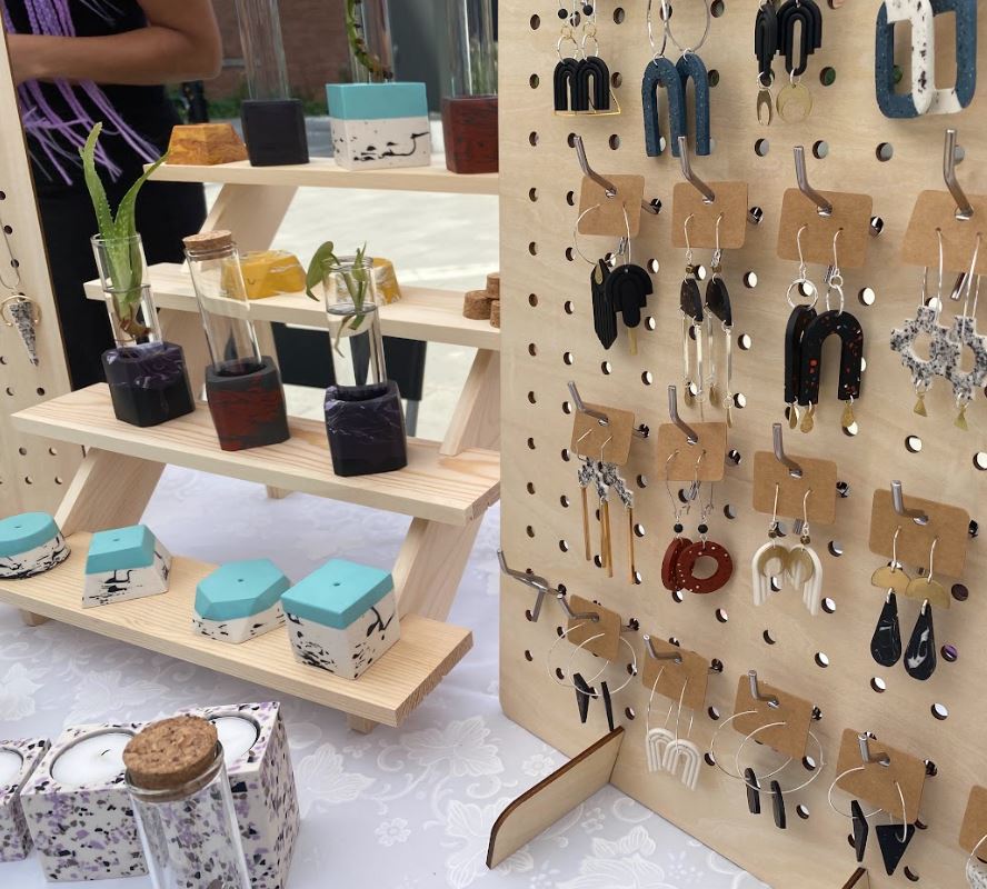 At the outdoor market, vendors display their handmade products. 