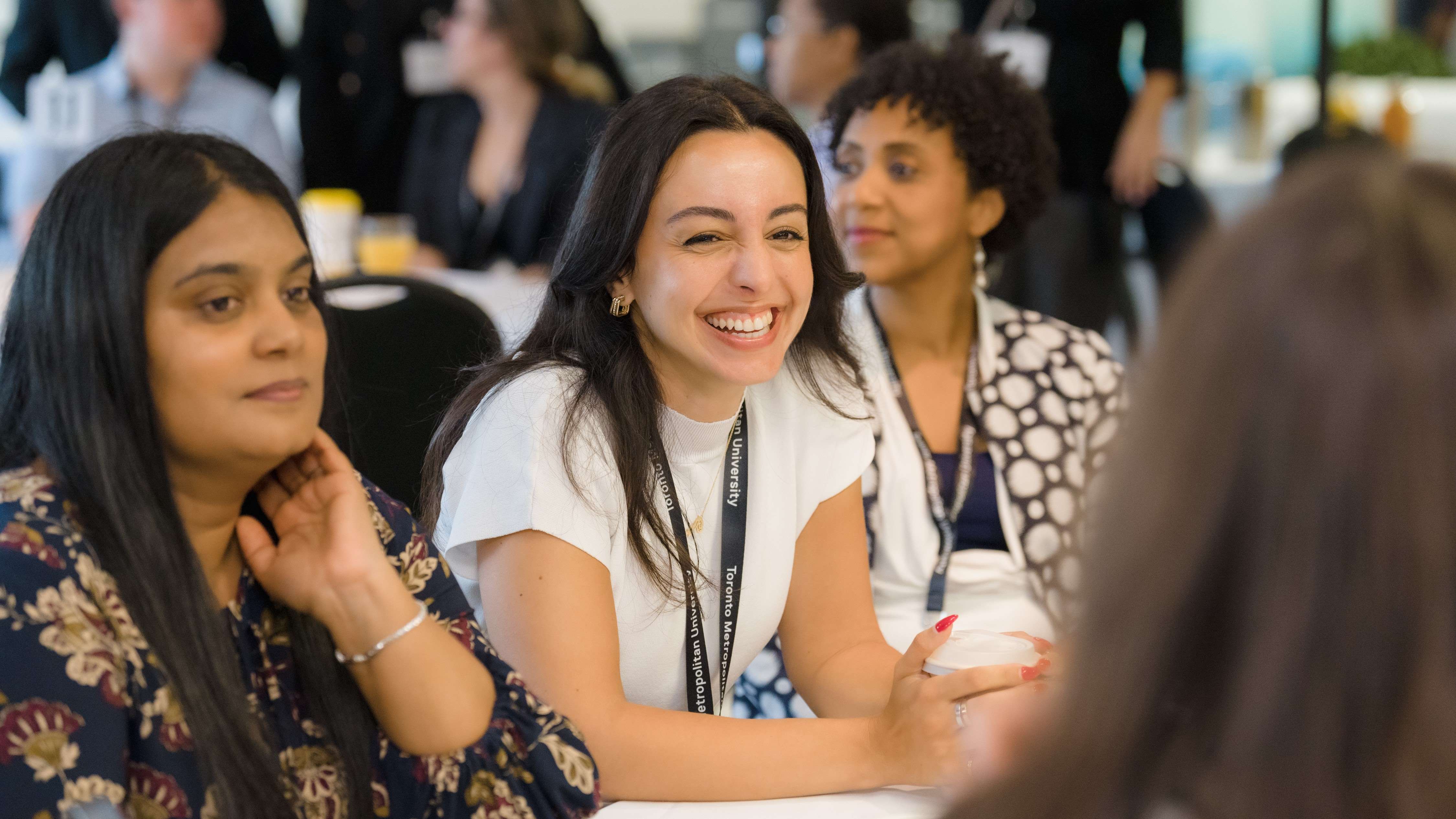 A Diversity Institute staff member smiling surrounded by colleagues at an event.