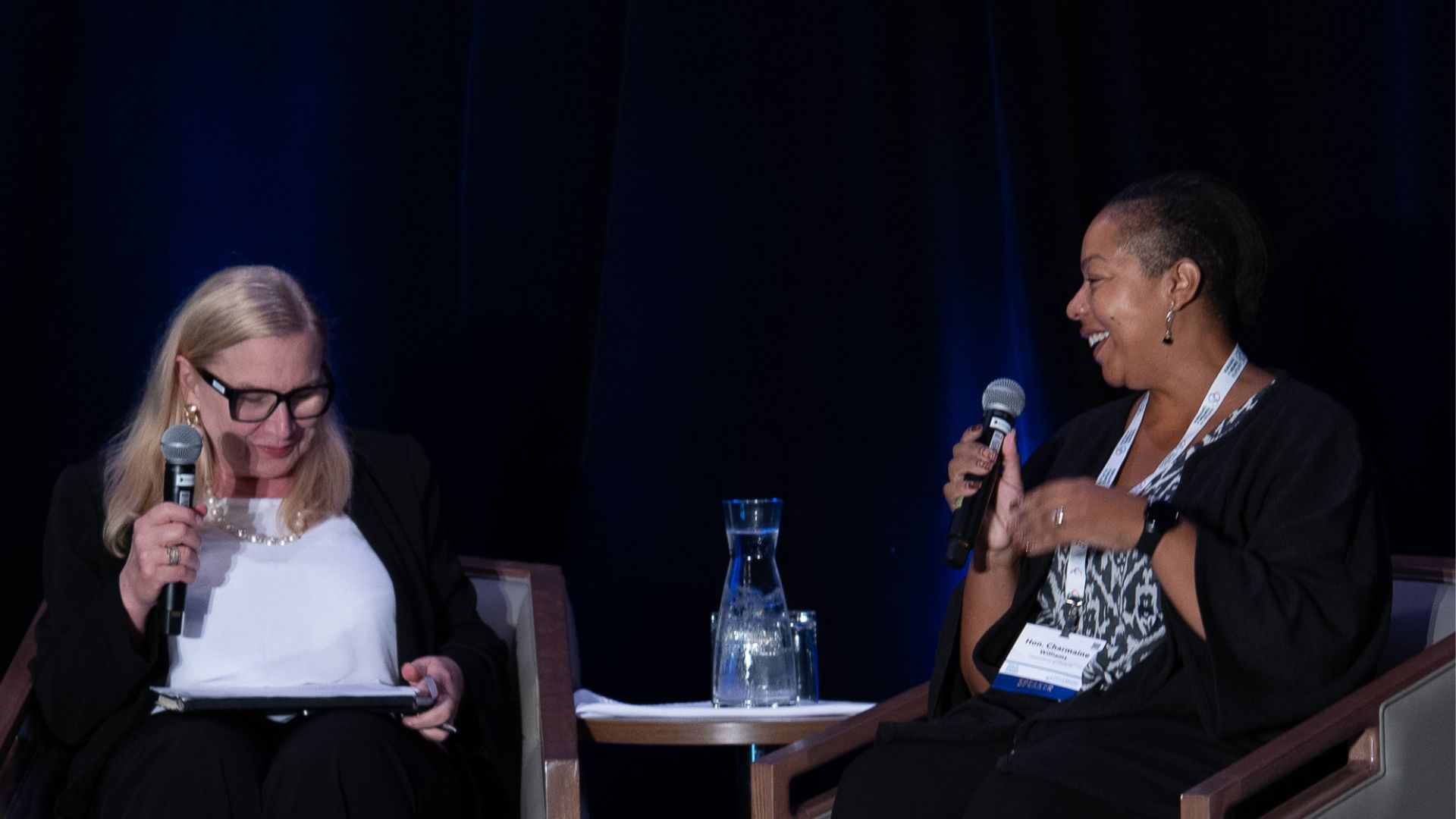Two women are having a discussion on stage.