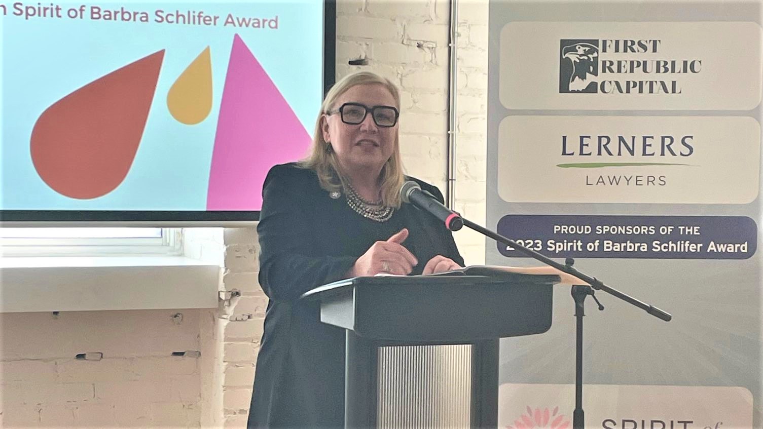 Wendy Cukier stands at a podium at the 2023 Spirit of Schlifer award ceremony.