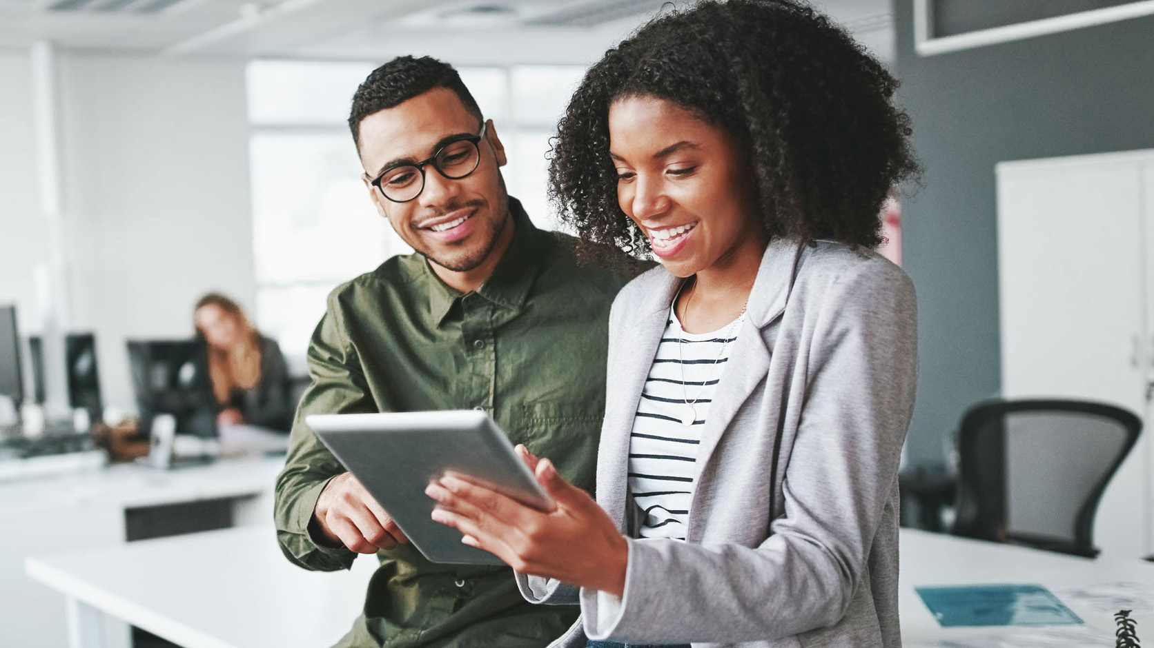 Two people work on a tablet.